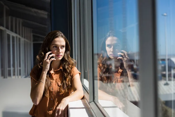 Podnikatelka, mluví o telefonu oknem — Stock fotografie