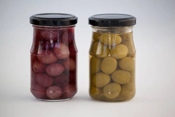 Green and brown olives in jar — Stock Photo, Image