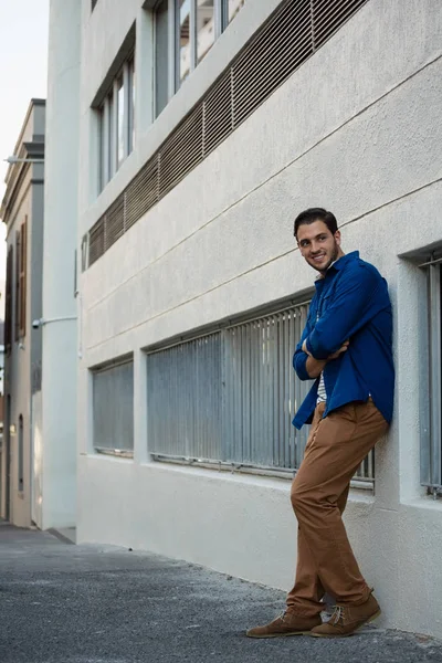 Homme avec les bras croisés appuyé sur le mur — Photo