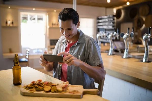 Hombre tomando una foto de la comida en el teléfono — Foto de Stock