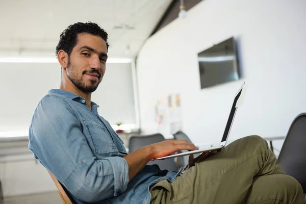 Young man using laptop in office — Stock Photo, Image