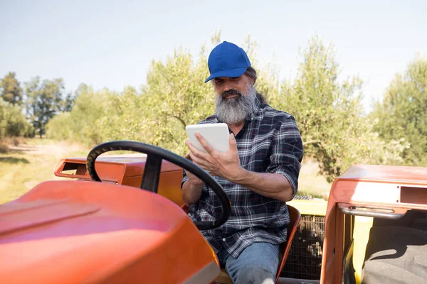 Homme utilisant une tablette numérique en tracteur — Photo