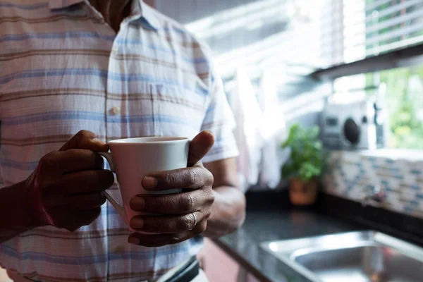 Man met koffiekopje door raam — Stockfoto