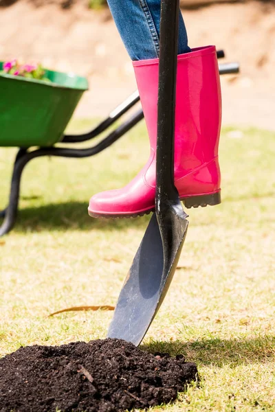 Frau in Gummistiefel mit Schaufel — Stockfoto