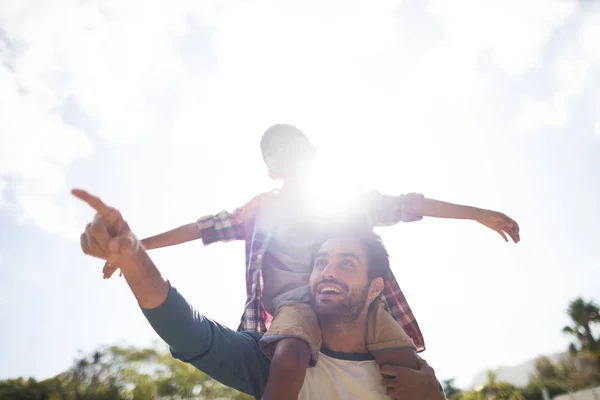 Father gesturing while carrying son on shoulder — Stock Photo, Image