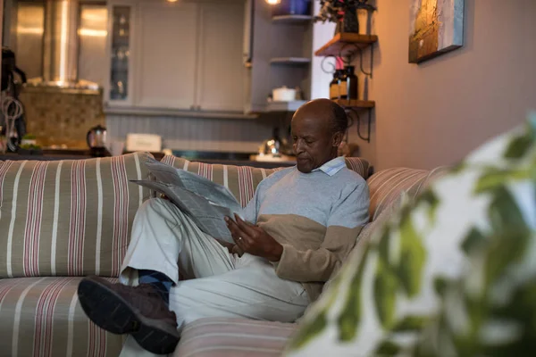 Senior liest Zeitung zu Hause — Stockfoto