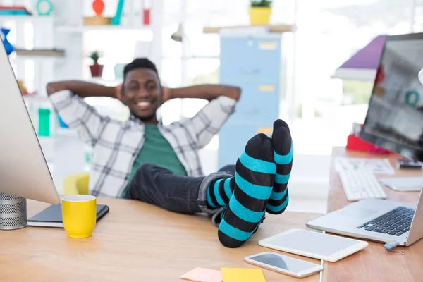 Mannelijke uitvoerend ontspannen achter zijn Bureau in kantoor — Stockfoto