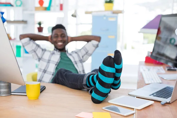 Executivo masculino relaxante em sua mesa no escritório — Fotografia de Stock