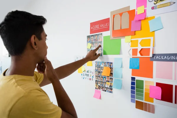 Man pointing at sticky notes in office — Stock Photo, Image