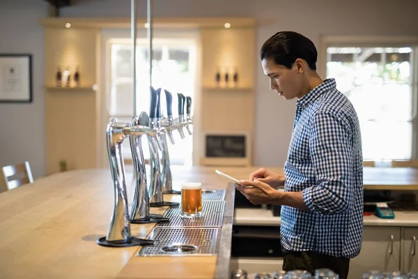 Bartender mit digitalem Tablet am Tresen — Stockfoto