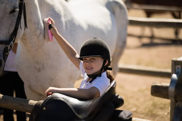 Menina arrumando o cavalo no rancho — Fotografia de Stock