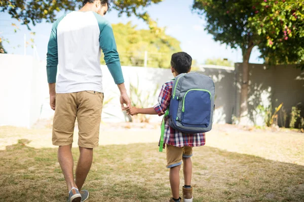 Far håller hand son med ryggsäck — Stockfoto