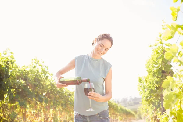 Kvinna hälla vin från flaska i glas — Stockfoto