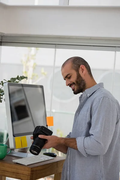 Designer examining camera at studio — Stock Photo, Image