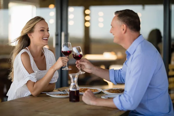 Пара тостов за бокалом вина во время еды — стоковое фото