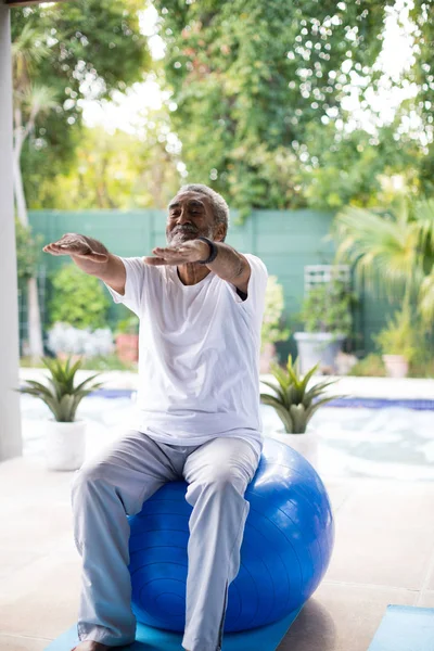 Homem sênior exercitando no quintal de bolas de fitness — Fotografia de Stock