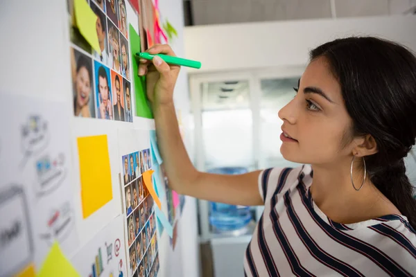 Businesswoman writing on sticky note — Stock Photo, Image