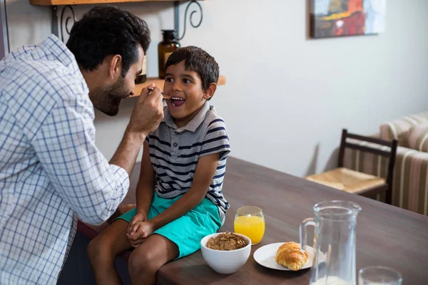 Otec syna krmení cereální snídaně — Stock fotografie