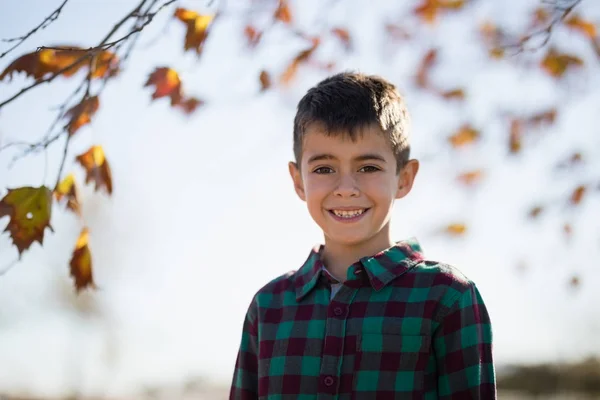 Sorridente ragazzo in piedi nel parco — Foto Stock