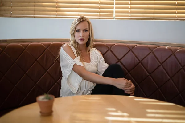 Жінка сидить на дивані в ресторані — стокове фото