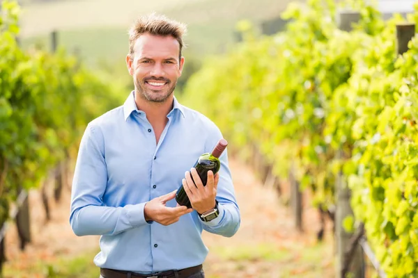 Homem segurando garrafa de vinho — Fotografia de Stock