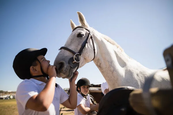 Garoto beijando o cavalo branco no rancho — Fotografia de Stock