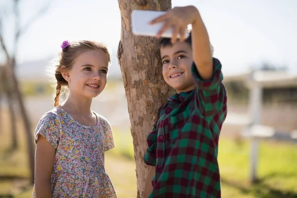 Rodzeństwo, biorąc selfie na telefon komórkowy — Zdjęcie stockowe