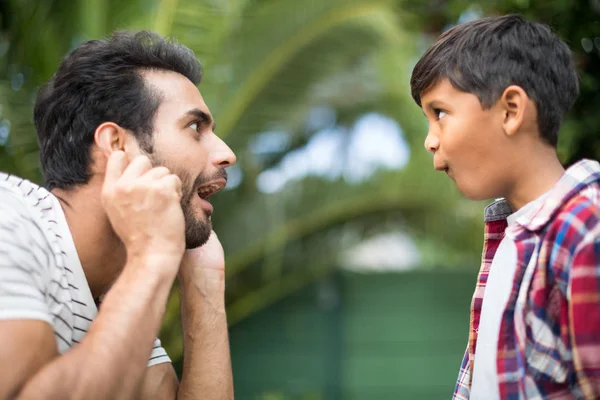 Pai e filho fazendo rostos enquanto joga — Fotografia de Stock