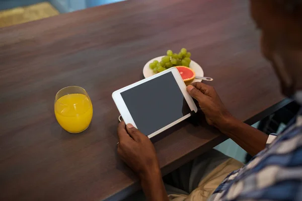 Hombre usando la tableta mientras está sentado en la mesa — Foto de Stock