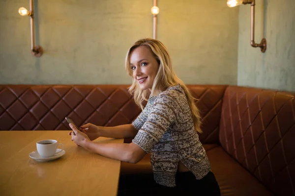 Frau benutzte Handy am Tisch — Stockfoto