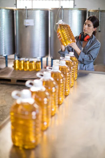 Trabajadora revisando botellas de aceite — Foto de Stock