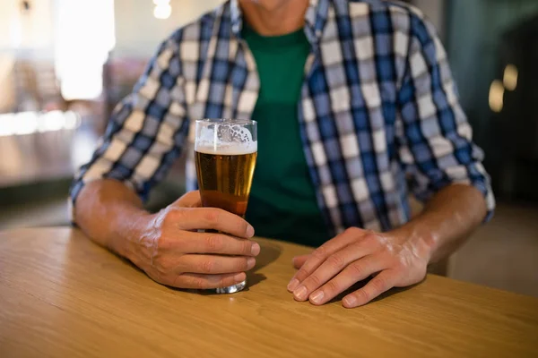 Homme assis avec un verre de bière — Photo
