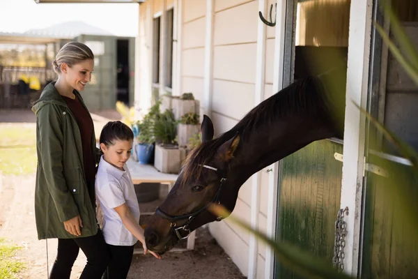 Mother and daughter feeding a horse — Stock Photo, Image