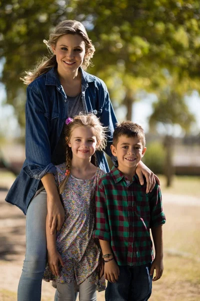 Mutter und Kinder stehen zusammen im Park — Stockfoto