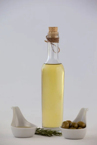 Aceitunas y hierbas con botella de aceite — Foto de Stock