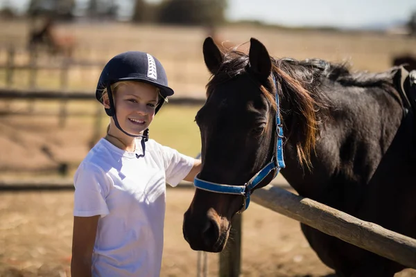 Dívka stojící vedle hnědý kůň — Stock fotografie