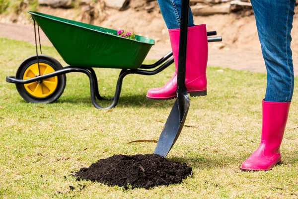 Woman in pink boots with shovel — Stock Photo, Image