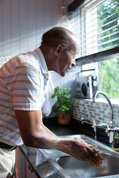 Hombre mirando hacia otro lado mientras se lava las manos — Foto de Stock