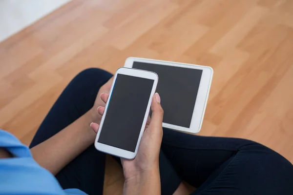 Mujer ejecutiva sosteniendo teléfono y tableta — Foto de Stock