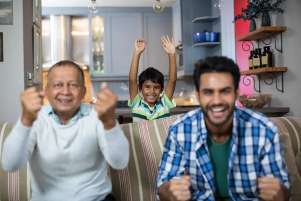 Familia apretando el puño mientras mira el partido de fútbol —  Fotos de Stock