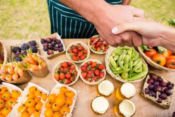 Mulher apertando a mão com homem vendendo frutas — Fotografia de Stock