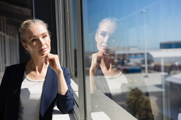 Thoughtful businesswoman looking through window — Stock Photo, Image