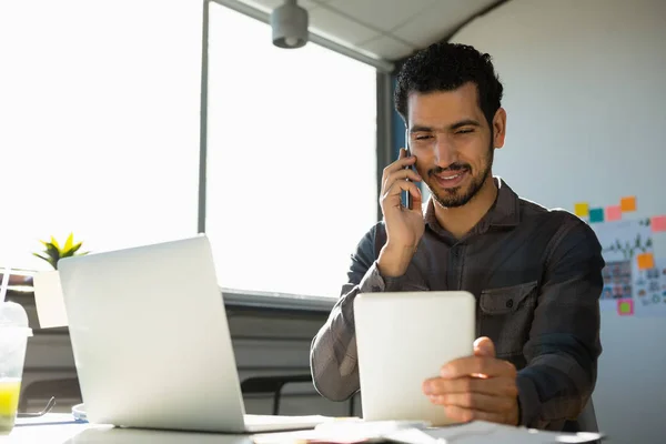 Hombre hablando por teléfono mientras usa la tableta —  Fotos de Stock