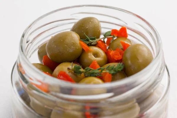 Green olives with herbs in jar — Stock Photo, Image
