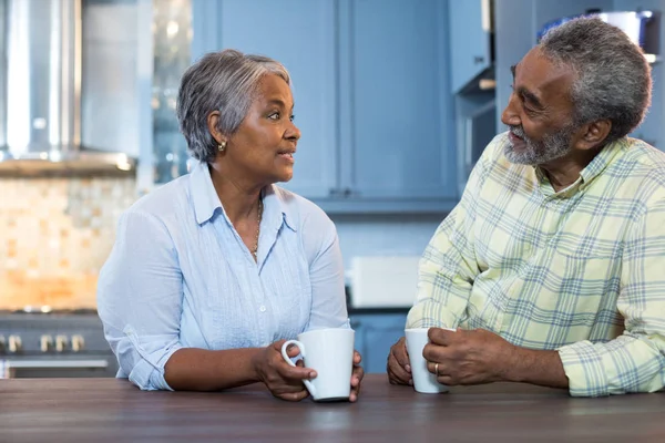 Couple talking while having coffee in kitchen — Stock Photo, Image