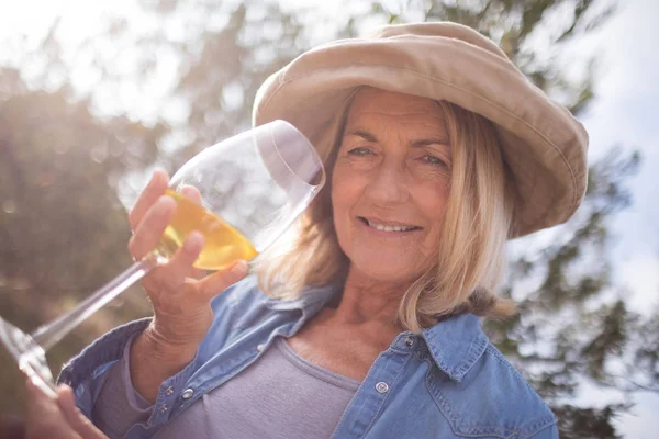 Vrouw kijken naar glas wijn in olijven boerderij — Stockfoto