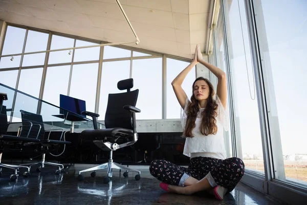 Businesswoman with eyes closed doing yoga — Stock Photo, Image