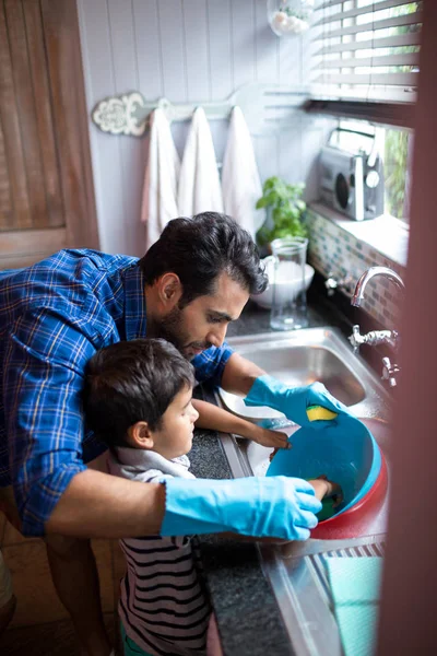 Vader zoon bijstaan voor het schoonmaken van gebruiksvoorwerpen — Stockfoto