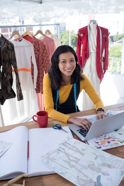 Diseñador femenino usando el ordenador portátil — Foto de Stock