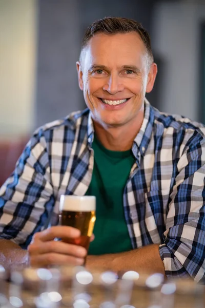 Man having glass of beer at counter — Stock Photo, Image
